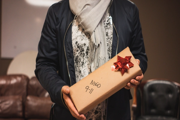 Persona sosteniendo un regalo que conviene evitar envuelto en papel kraft